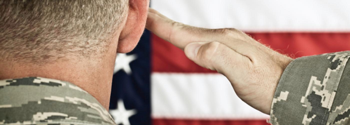 Military soldier saluting American flag